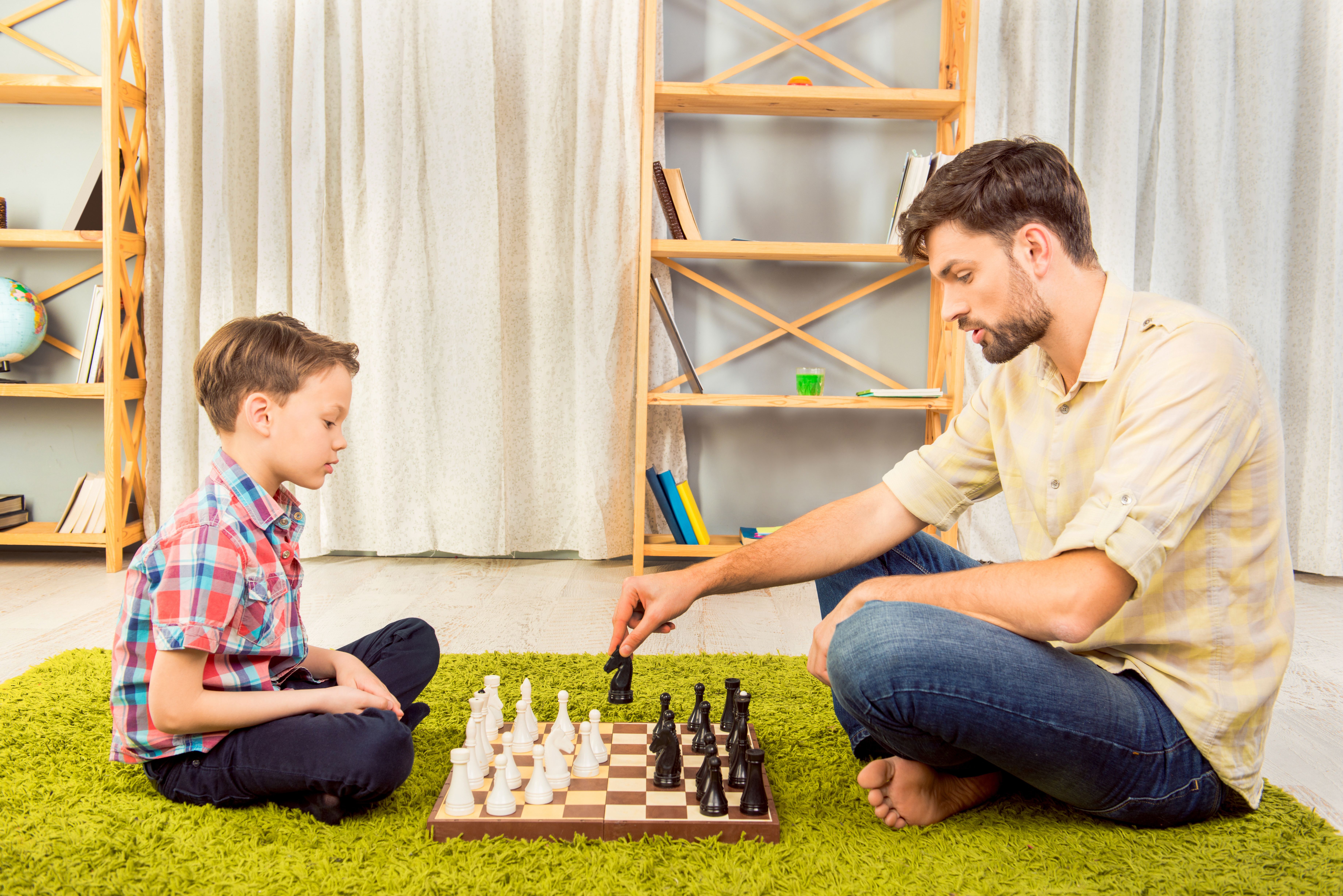 Папа играет в шахматы. Папа с сыном играют в шахматы. Играющие в шахматы сын и отец. Папа с сыном играют в шахматы фото.